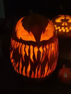 two carved pumpkins sitting on top of a table