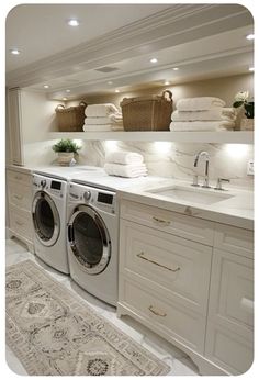 a washer and dryer in a very large room with lots of towels on the wall