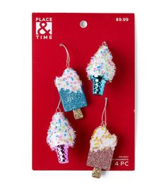 three ice cream earrings are shown on a red card with white and blue glitters