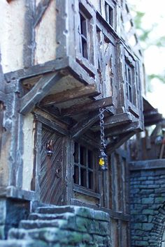 an old building with wooden windows and chains hanging from it's sides