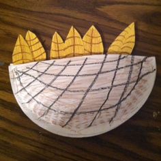 a paper plate with yellow and black designs on it, sitting on a wooden table