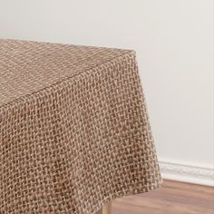 a close up of a table cloth on a wooden table with white walls in the background