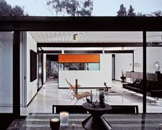 the dining table is surrounded by black and white chairs, with an orange accent on the wall