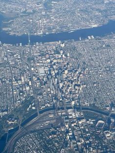 an aerial view of a city with lots of tall buildings and water in the foreground