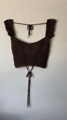 a crocheted crop top hanging on a wall