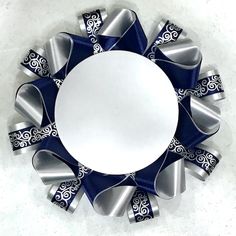 a blue and silver decorative object on a white surface with an empty circle in the middle