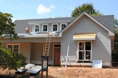 a house under construction with a ladder on the roof