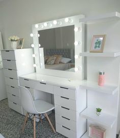 a white vanity with lights on it and a chair in front of the mirror that is lit up