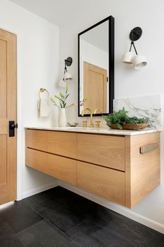 a bathroom with a large mirror, sink and wooden cabinetry on the countertop