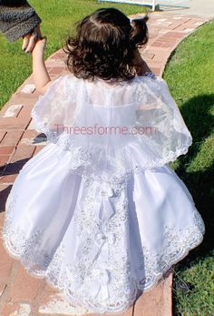 "Our Virgin Mary Embroidered Baptism Collection is here! All our dresses are made here in the United States. A 3 pcs dress: includes dress, cape and headband. Our dresses are made of satin, organza and tull. We use satin on our beautiful dresses and organza on capes. Corset on both sides to adjust for perfect fit. A large Virgin Mary Embroidery on chest of dress. Translucent chest top. Dress is high-low cut which means dress has a train on back with beautiful bows. Cape is button attached. fresh Bautizo Ideas Girl Dress, Virgin Mary Embroidery, Mary Embroidery, Bautizo Ideas, Dress Cape, Baptism Gown, Baptism Candle, Baptism Dress