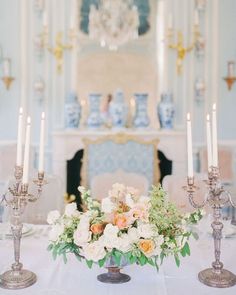 an elegant centerpiece with flowers and candles on a table