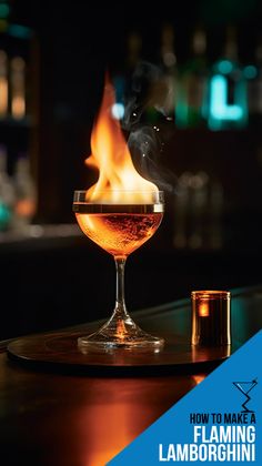 a close up of a wine glass on a table with a fire in the background