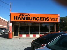 the front of a restaurant called hamburgers with cars parked outside