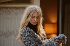 a woman with long blonde hair is looking down at her cell phone