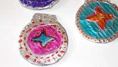 three different colored paper plates with stars on them and confetti around the edges