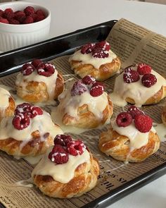 there are many croissants with raspberries on them in the tray