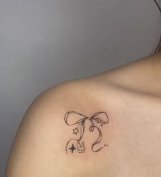 a woman with a tattoo on her shoulder that has an image of a dog and stars