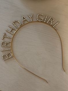 a gold headband with the word bride spelled out in crystal beads on top of it