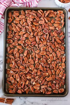 a baking pan filled with pecans on top of a marble counter