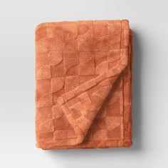 an orange towel folded on top of a white wall