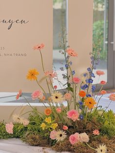 an arrangement of flowers is on display in front of a sign for the wedding venue