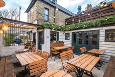 an outdoor dining area with wooden tables and chairs