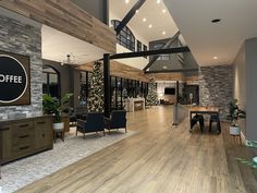 a large open living room with wood flooring and stone walls, along with a coffee sign on the wall