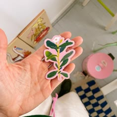 a person holding up a sticker with a plant on it's side in their hand