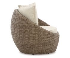 a brown wicker chair with a white pillow on it's back and seat cushion