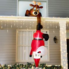 an inflatable santa clause and reindeer on top of a house