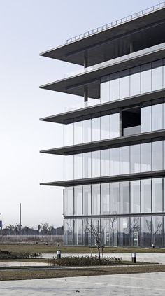 an empty parking lot in front of a tall building with lots of windows and balconies