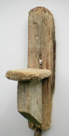 a piece of wood that is attached to a wall with a small hole in it