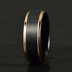 a black and gold wedding ring on a table