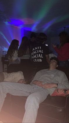 a group of people sitting on top of a couch in a room filled with lights