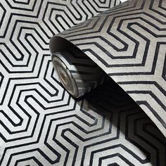 a black and white tie laying on top of a floor next to a roll of tape