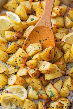 a wooden spoon sitting on top of potatoes and lemons in a casserole dish