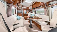 the interior of a recreational vehicle with white leather seats and wood trimmings on the walls