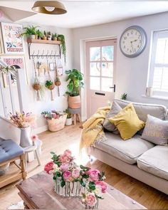 a living room filled with lots of furniture and flowers on the table in front of it