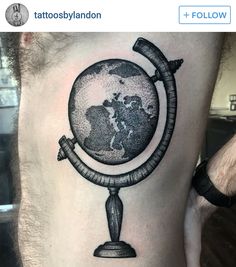 a man's thigh with a globe tattoo on it