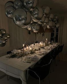 a long table is set with silver balloons and candles