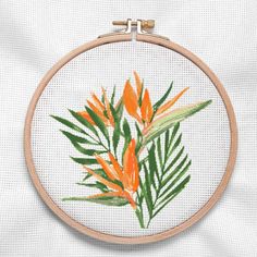 an embroidery project with orange flowers and green leaves