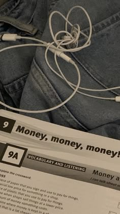 a pair of jeans and headphones are sitting on top of a paper with the words money, money, money