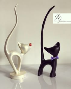 two black and white cat figurines sitting next to each other