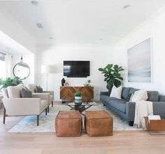 a living room filled with furniture and a flat screen tv mounted to the side of a wall