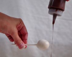 a person is pouring chocolate onto a spoon