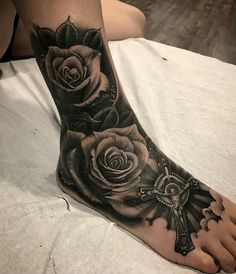 a woman's foot with roses and a cross on the top of her leg