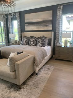 a large bed sitting in the middle of a living room next to a dresser and chair