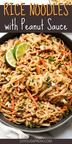 rice noodles with peanut sauce in a skillet topped with lime wedges and garnished with parsley