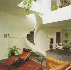 a living room filled with furniture and a spiral staircase