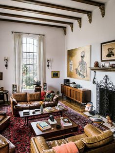 a living room filled with furniture and a large painting hanging on the wall above it